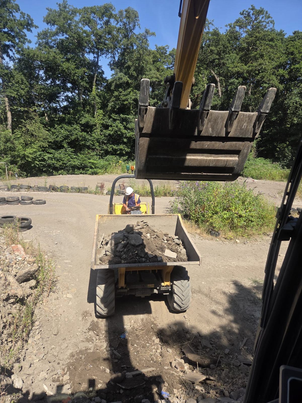 Excavator operator loading a dumper on a live operating site